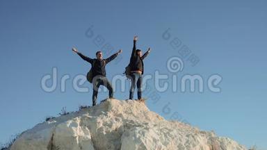 两个男子游<strong>客徒步</strong>探险<strong>登山</strong>者<strong>登山</strong>成功手把自由举起。 慢动作视频。 hike
